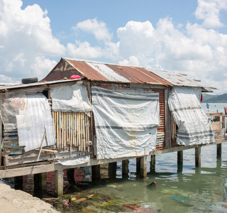 This fragile tarpaulin home represents a typical house in the Anibong community that was left in Haiyan’s wake. It stands in stark contrast to the resilient and safe homes CRS built at the Anibong resettlement site. Photo by Jennifer Hardy/CRS.
