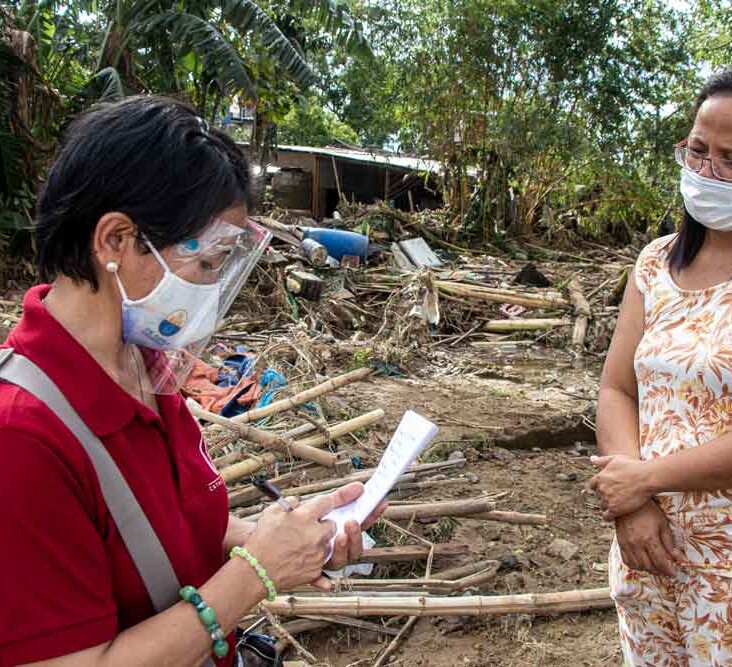 A CRS staff member speaks to a resident of Barangay Burgos.